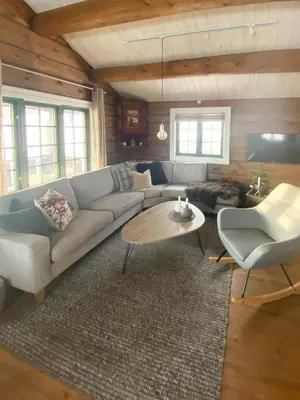a living room with a couch and a table at Charming Log Cabin In Jøldalen in Rennebu