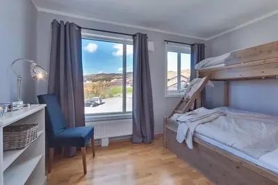 a bedroom with a bed and a desk and a window at Big And Modern Apartment At Beitostølen in Beitostøl