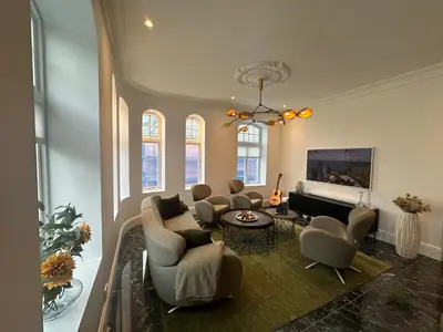a living room with chairs and a table at Elegant Three-Bedroom Apartment with Stunning Sea Views - Limited availability - Secure your booking for Summer in Ålesund