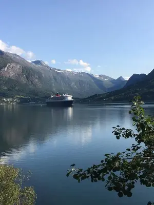 a boat on a large body of water with mountains at Lovely apartment in beautiful Loen in Loen