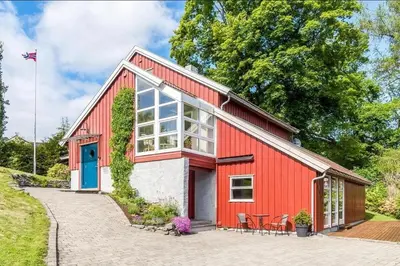 a red barn with a blue door and chairs at 5 room apartment for Ski-World Championship in Trondheim