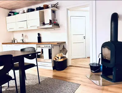 a kitchen with a fireplace and a table and a stove at 5 room apartment for Ski-World Championship in Trondheim