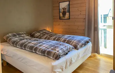 a bed with a blanket on it in a room at Stunning Home In Bjorli With Wifi in Bjorli