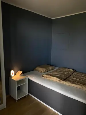 a small bedroom with a bed and a night stand at Apartment in Trondheim, Tiller in Trondheim