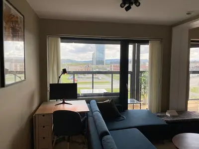a living room with a blue couch and a large window at Apartment in Trondheim, Tiller in Trondheim