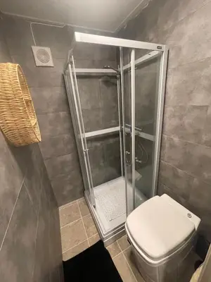 a bathroom with a shower and a toilet at Bekkvang Fjøs Tiny House in Trysil