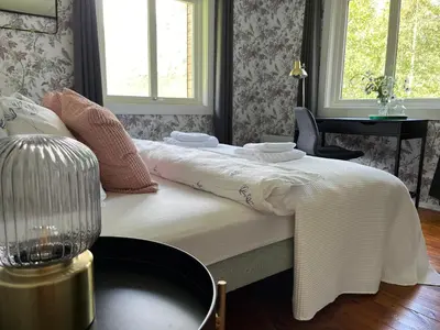 a bedroom with a bed with a white blanket on it at Villa Fjellheim in Luster