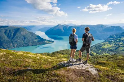 two people standing on top of a mountain overlooking a lake at Villa Fjellheim in Luster