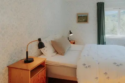 a bedroom with a bed and a lamp on a night stand at Villa Fjellheim in Luster
