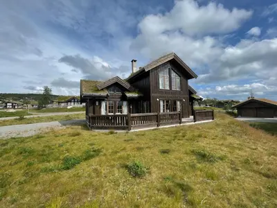 a house on top of a grassy field at Mountain Retreat Near Hiking And Skiing in Beitostøl