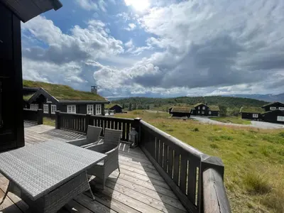 a wooden deck with a table and benches on it at Mountain Retreat Near Hiking And Skiing in Beitostøl