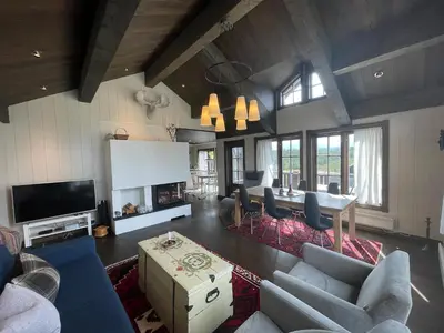 a living room with a table and chairs and a tv at Mountain Retreat Near Hiking And Skiing in Beitostøl
