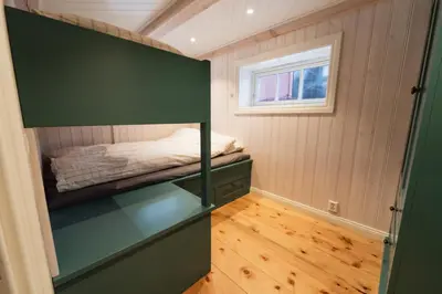 a small bedroom with a bed and a window at Leilighet i stall fra 1800-tallet in Os