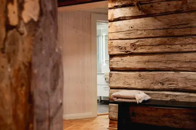 a log wall in a room with a bed at Leilighet i stall fra 1800-tallet in Os