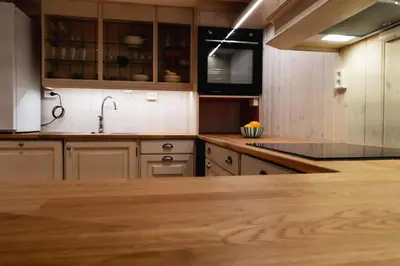 a kitchen with wooden cabinets and a wooden counter top at Leilighet i stall fra 1800-tallet in Os