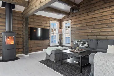 a living room with a couch and a fireplace at New Timber Lodge With Stunning Views And Comfort in Beitostøl