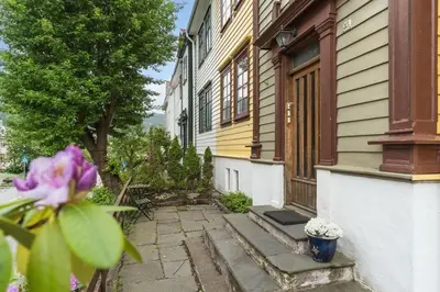 a house with a purple flower in front of it at Urban retreat, traditional wooden house in Bergen in Bergen