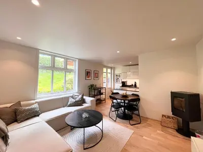 a living room with a white couch and a tv at Urban retreat, traditional wooden house in Bergen in Bergen