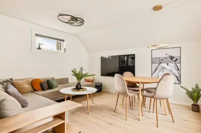 a living room with a table and chairs and a couch at DINBNB Apartment l Skansen funhouse - 400m to Bryggen Gym & Parking in Bergen