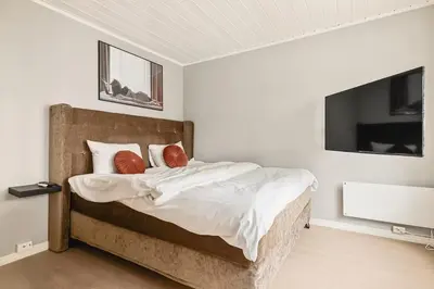 a bed with white sheets and red pillows in a bedroom at DINBNB Apartment l Skansen funhouse - 400m to Bryggen Gym & Parking in Bergen