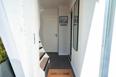 a hallway with a welcome mat on the floor at DINBNB Apartment l Skansen funhouse - 400m to Bryggen Gym & Parking in Bergen
