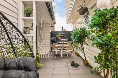 a balcony with a table and chairs and plants at DINBNB Apartment l Skansen funhouse - 400m to Bryggen Gym & Parking in Bergen