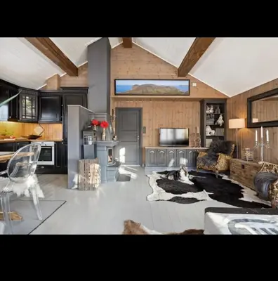 a large living room with a couch and a kitchen at Bjorli Mountain Cabin in Bjorli