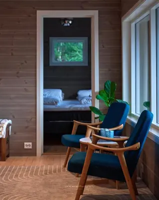 a room with two blue chairs and a table and a bed at Rjånes Ferie og Konferansesenter in Ørsta