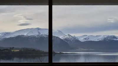 a view of a snowy mountain range from a window at Rjånes Ferie og Konferansesenter in Ørsta