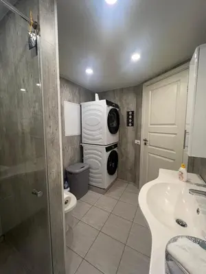a bathroom with a sink and a washing machine at Sokkelleilighet i enebolig i Ålesund nær stranden in Ålesund