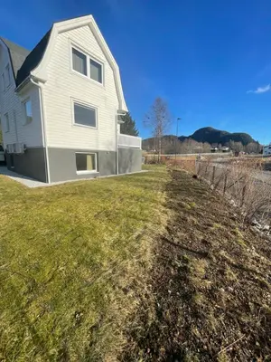 a house on the side of a field at Sokkelleilighet i enebolig i Ålesund nær stranden in Ålesund