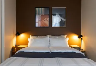 a bedroom with a bed with two pictures on the wall at Unique apartment in midtown in Trondheim