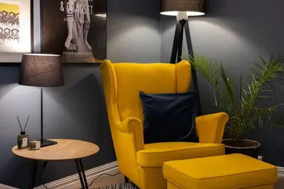 a yellow chair and a side table in a room at Unique apartment in midtown in Trondheim