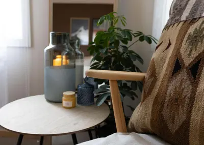 a table with a plant and a bottle on a chair at Unique apartment in midtown in Trondheim