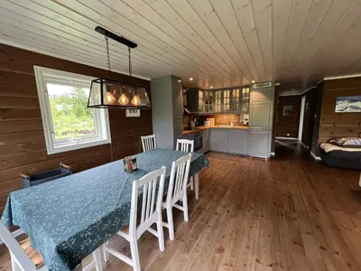 a dining room with a table and chairs and a kitchen at New Cozy Cabin By Ski Trails And Nature Paths in Beitostøl