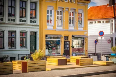 a yellow building with benches in front of it at Bergens Nr1 smau I Enkel innsjekk I Sjøutsikt in Bergen