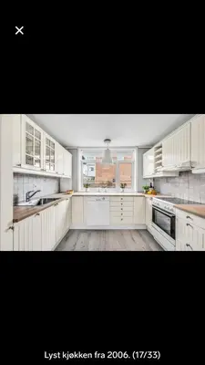 a large kitchen with white cabinets and a window at Koselig rekkehus til leie under ski VM i Trondheim in Trondheim