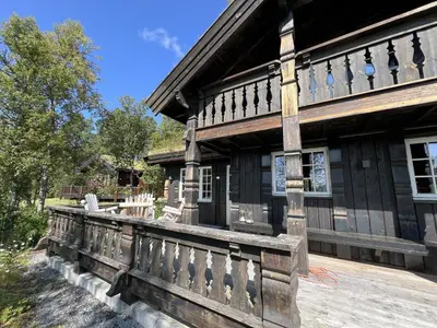 a wooden house with a wooden fence in front of it at Relaxing Getaway With Sauna And Terrace in Beitostøl