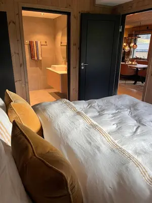 a large white bed in a room with a bathroom at Stylish apartment in Myrkdalen in Vossestrand