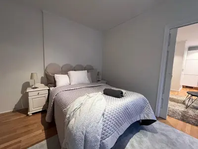 a bedroom with a bed with a white comforter at Apartment near City Center in Trondheim