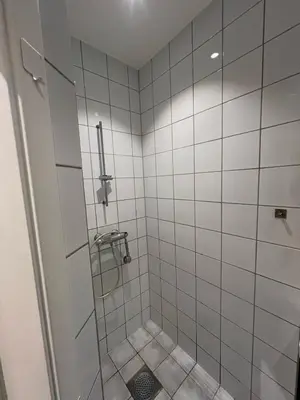 a bathroom with a shower with white tiles at Apartment near City Center in Trondheim