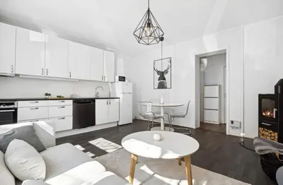 a white living room with a couch and a table at Modern apartment close to the city center in Trondheim