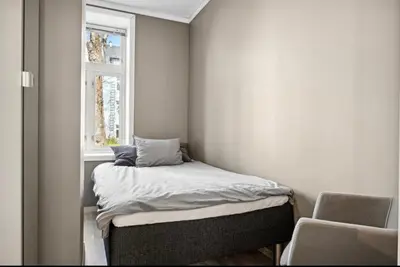 a small bedroom with a bed and a window at Modern apartment close to the city center in Trondheim