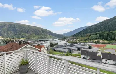 a view of a town with a white fence at 4 roms leilighet ved Fosshaugane Campus in Sogndal
