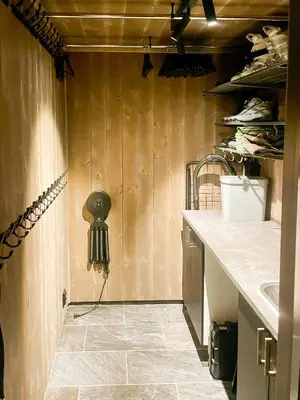 a kitchen with a sink and a wall with wood at Mountain Cabin At Hardangervidda in Uvdal