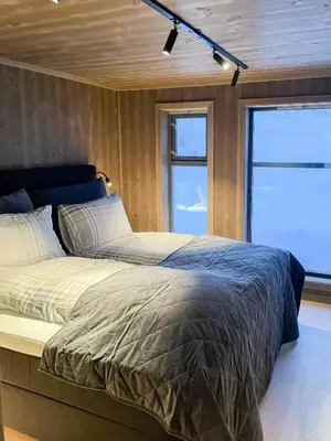 a large bed in a room with two windows at Mountain Cabin At Hardangervidda in Uvdal