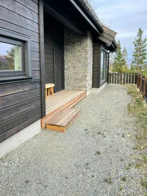 a house with a wooden porch on the side of it at Modern Cabin At The Gateway To Jotunheimen in Randsverk