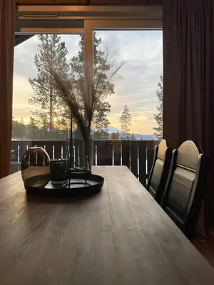 a dining room table with a view of a tree at Modern Cabin At The Gateway To Jotunheimen in Randsverk