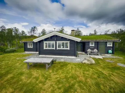 a small blue house with a grass roof at Charming Cabin Near Jotunheimen Trails in Beitostøl
