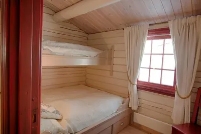 a small cabin with a bed and a window at Charming Cabin Near Jotunheimen Trails in Beitostøl